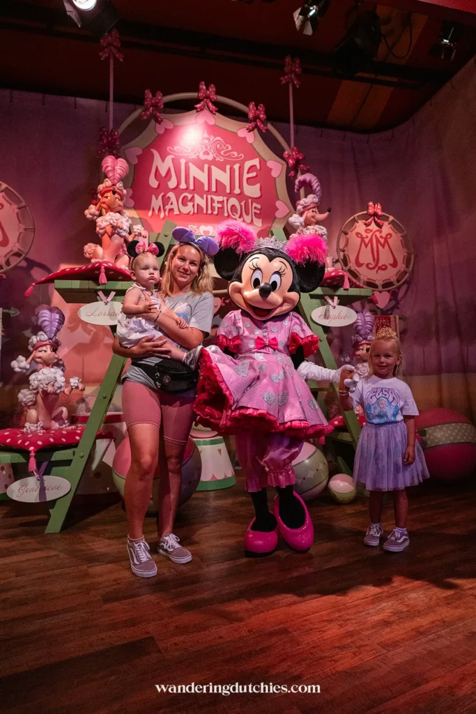Moeder en twee dochters op de foto met Minnie Mouse in een roze prinsessenkamer tijdens een Meet & Greet in Walt Disney World.