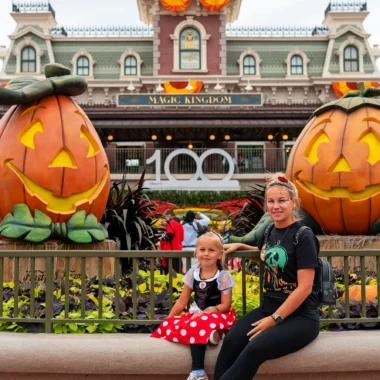 Marissa en Nina zitten voor de ingang van Magic Kingdom in Walt Disney World tijdens het Mickey's Not-So-Scary Halloween Party event.