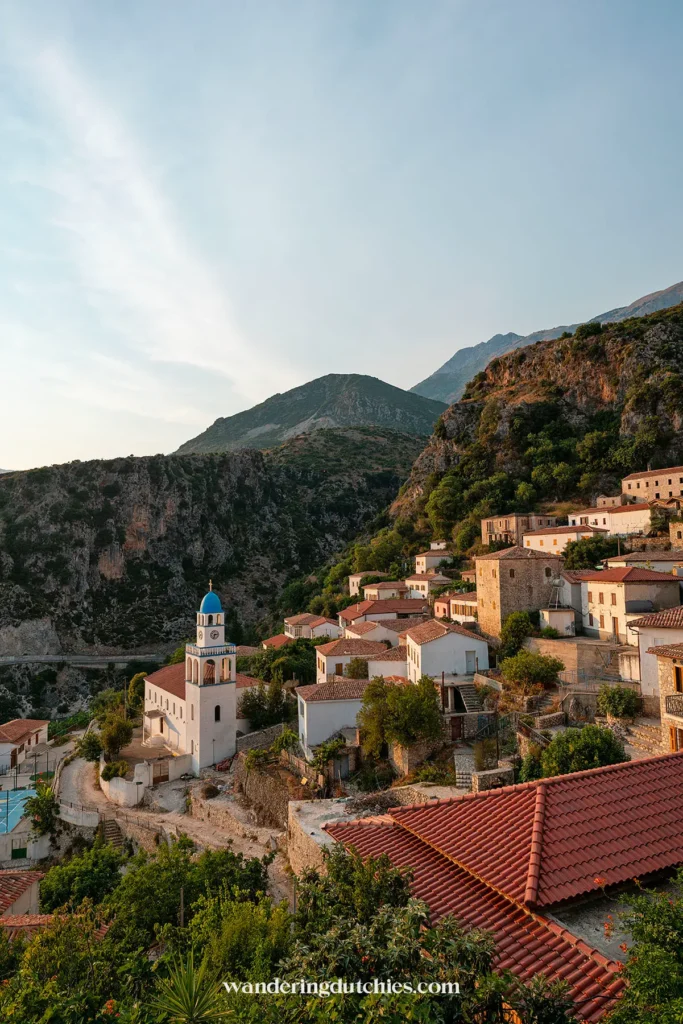Charmant bergdorpje Dhermi in Albanië bij zonsondergang, een prachtige stop als je gaat autorijden (als je bv. een auto gaat huren) in Albanië.
