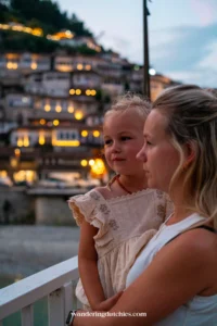 Moeder en dochter genieten van het uitzicht op de verlichte huizen in Berat, Albanië.