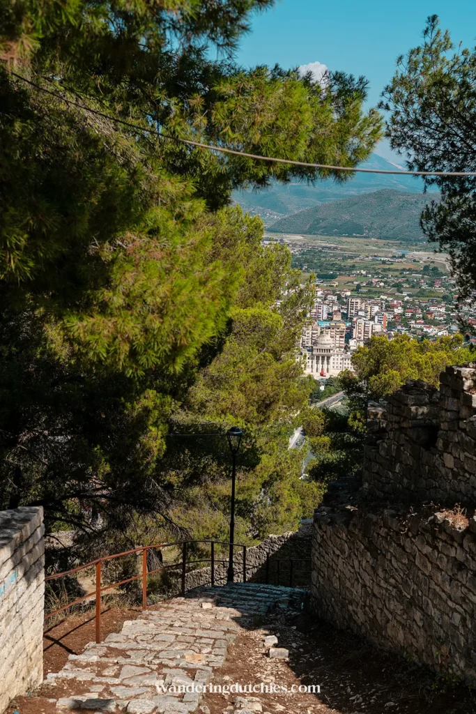 Een pad door de bossen in Berat Castle met uitzicht op de stad Berat beneden.