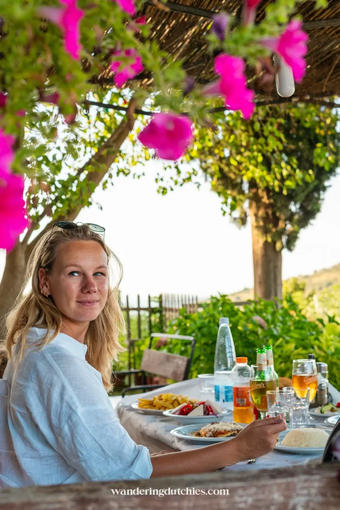Ontspannen lunchmoment bij Te Zalua Restaurant, met kleurrijke bloemen op de voorgrond.