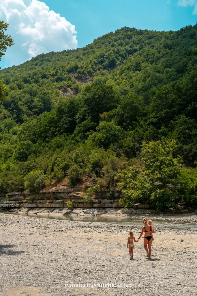 Moeder wandelt met twee kinderen over de rivierbedding bij Osumi Canyon.