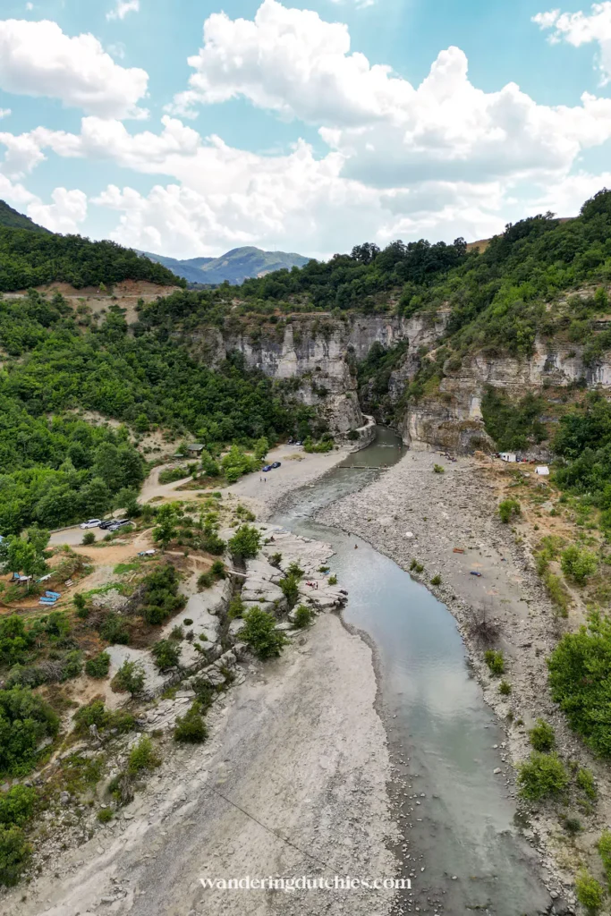 Luchtfoto van Osumi Canyon met de rivier, een camping en omliggende heuvels.