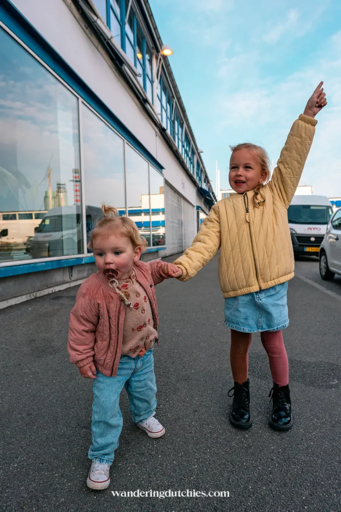 Twee kinderen hand in hand bij een industrieel gebouw in Kødbyen, Kopenhagen.