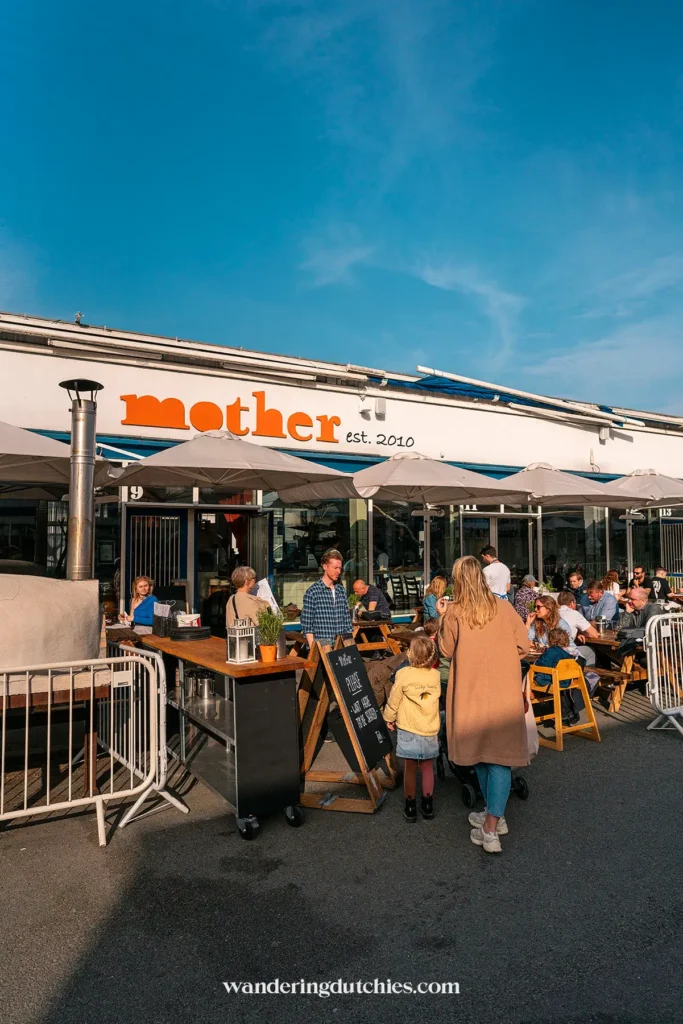 Moeder en kind lopen langs restaurant Mother in Kødbyen, Kopenhagen.