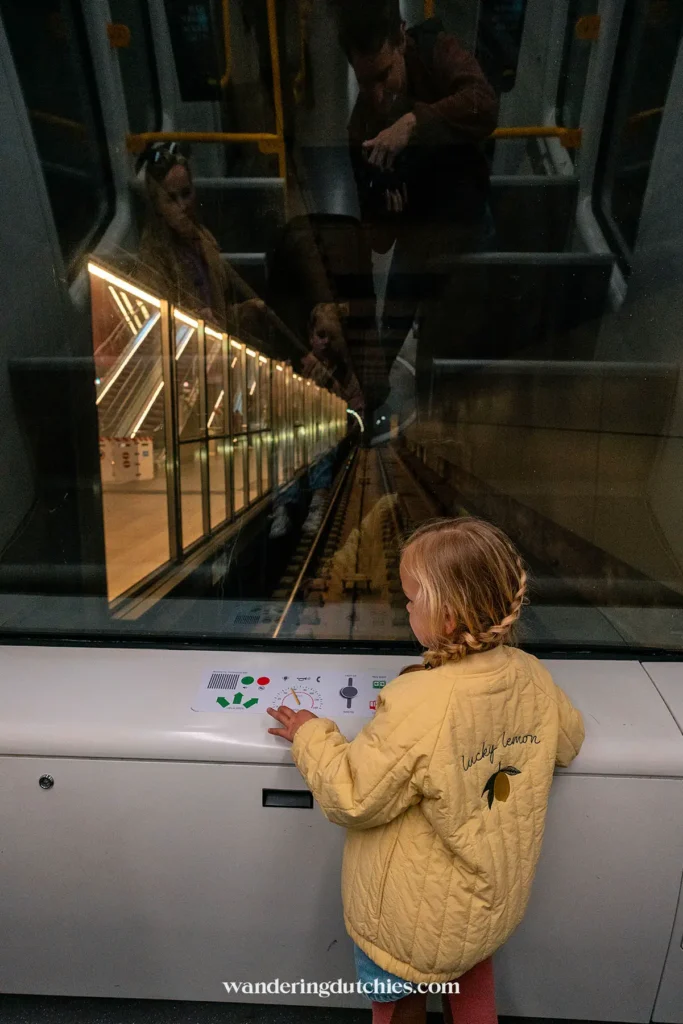 Jonge reiziger kijkt nieuwsgierig uit het voorraam van een zelfrijdende metro in Kopenhagen.