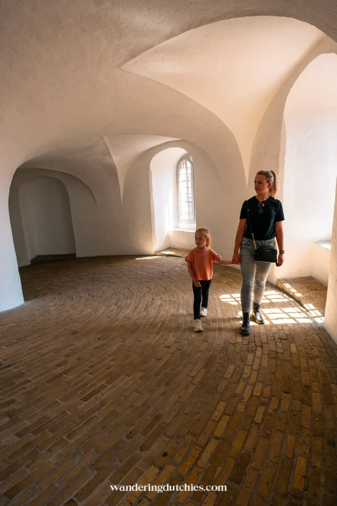 Moeder en kind wandelen door de spiraalvormige helling in de Rundetaarn, Kopenhagen.