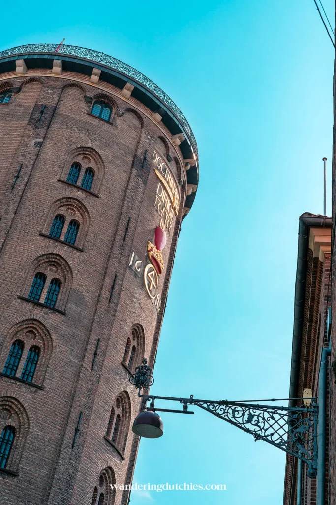 Uitzicht op de buitenkant van de Rundetaarn in Kopenhagen, met de historische gevel en blauwe lucht.