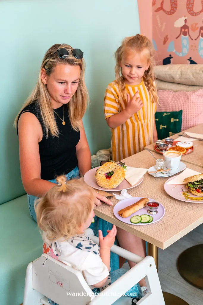 Moeder met twee jonge dochters genietend van een gezonde lunch bij Kids Concept Store Confetti in Maastricht, een ideale plek voor een uitje met kinderen.