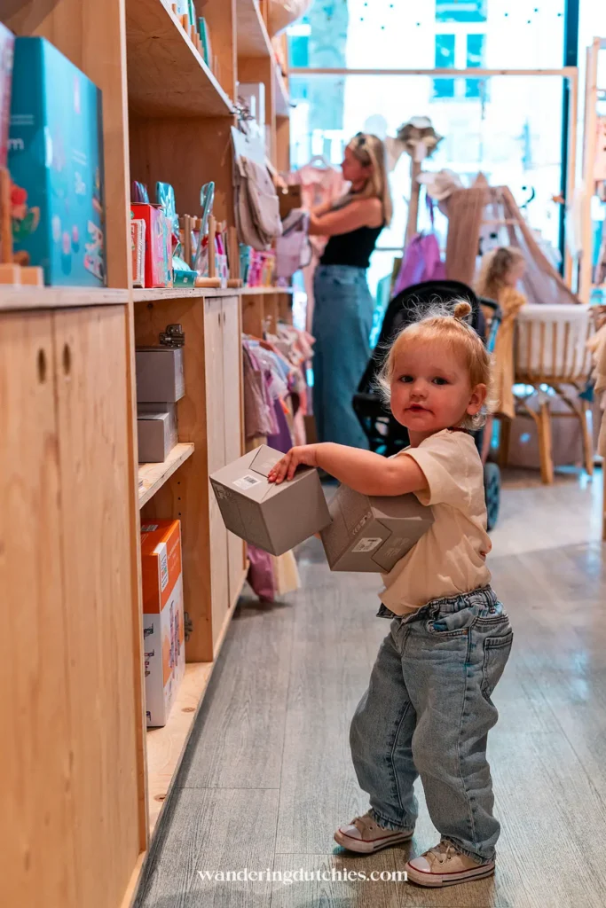 Peuter speelt met speelgoeddozen in de Kids Concept Store Confetti in Maastricht, een leuke winkel voor kinderen en families.