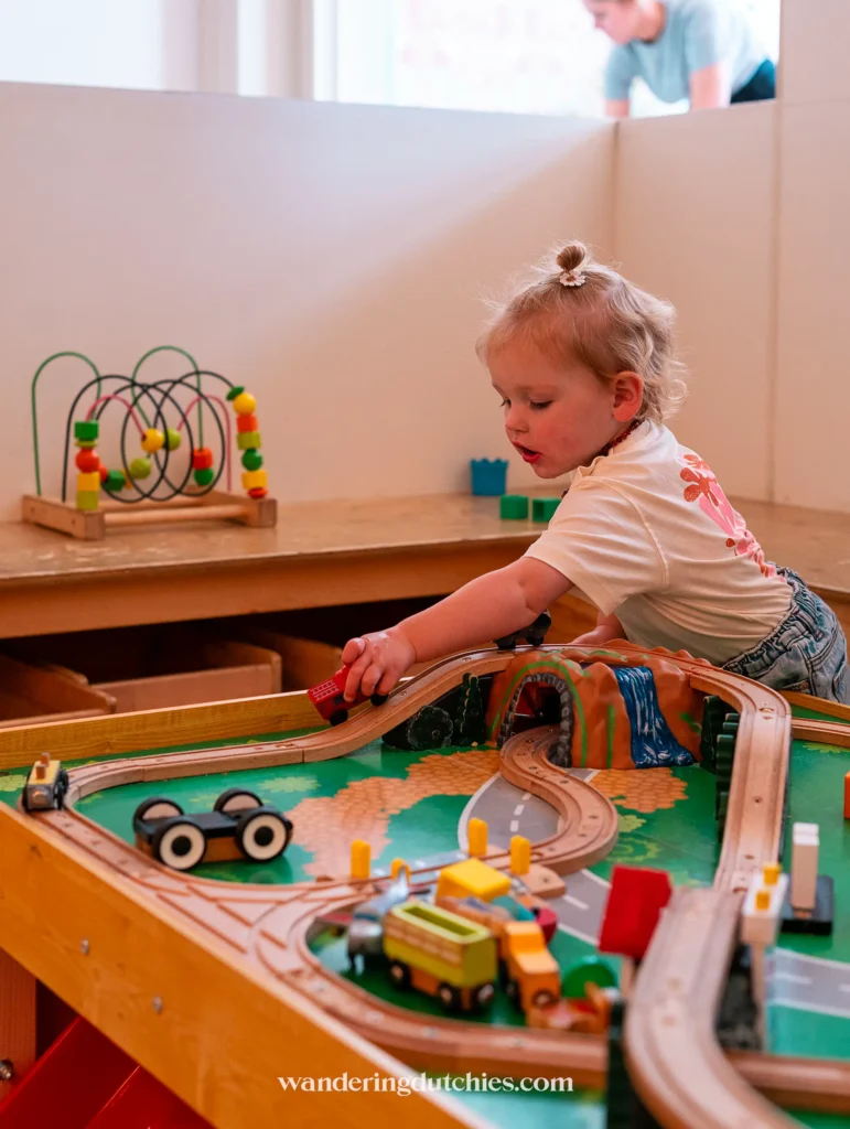 Peuter speelt met een houten treintafel in de speelhoek van Kids Concept Store Confetti in Maastricht, een leuke activiteit voor kinderen.