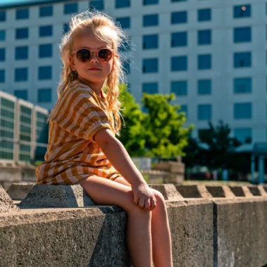 Nina geniet van een zonnige dag in het Sphinxkwartier in Maastricht, een leuke tip voor een bezoek aan Maastricht met kinderen.