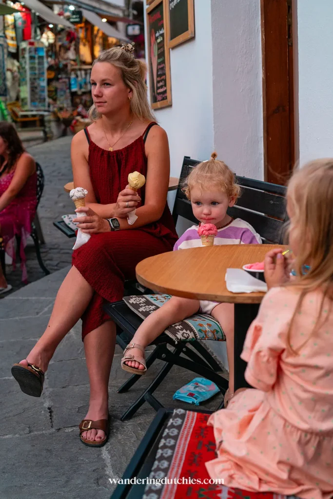 Mother and daughters enjoying ice cream on a cozy terrace in the old town of Gjirokastër, Albania.