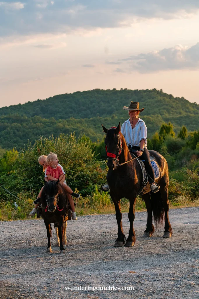 Family enjoying horseback riding in a beautiful landscape in Albania.