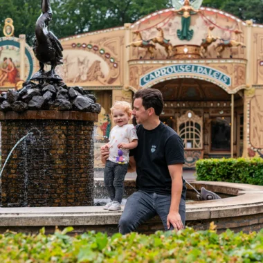 Vader met dochter bij een fontein voor het Carrouselpaleis in de Efteling
