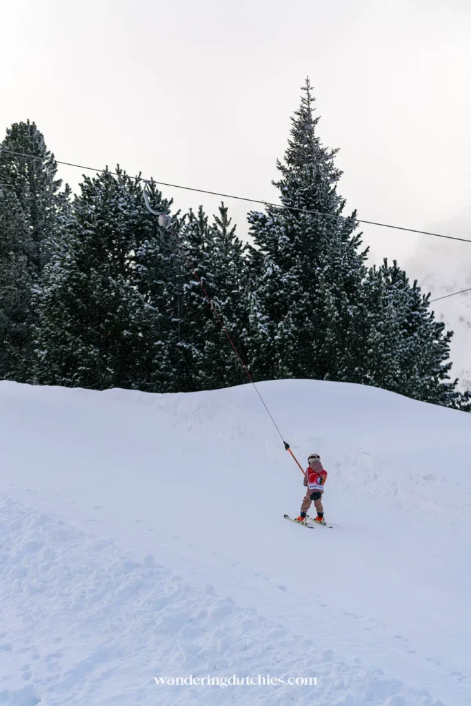 Kind op sleeplift in skigebied Spieljoch, Fügen, Oostenrijk tijdens een wintersportvakantie.