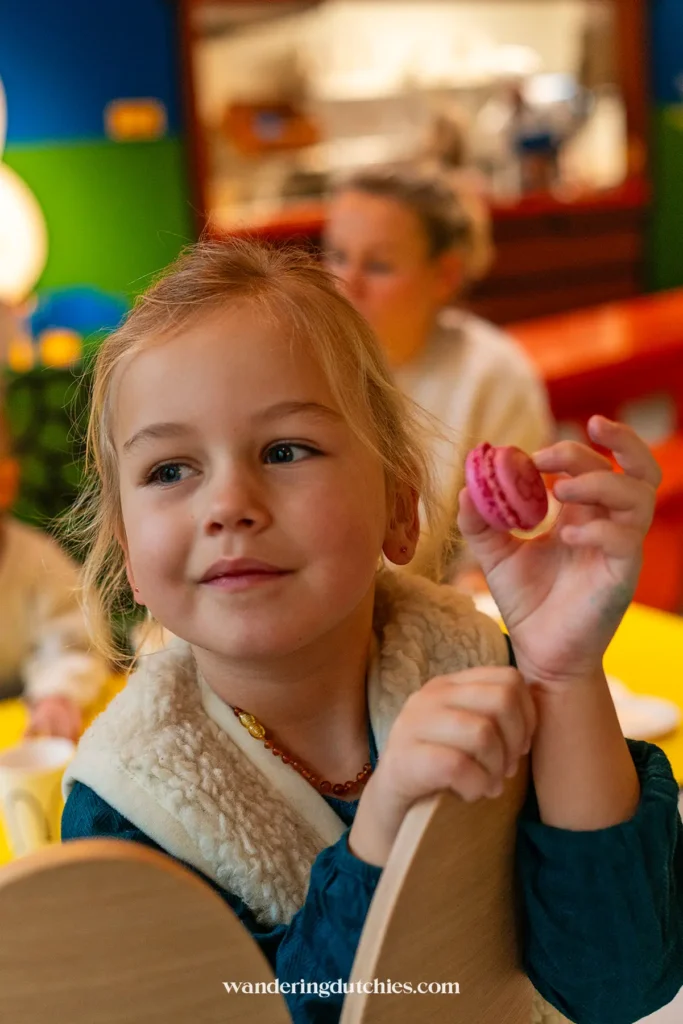 Klein meisje geniet van een macaron in het nijntje museum café in Utrecht.