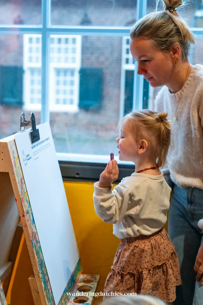 Klein meisje tekent op een ezel in het kunstlokaal van het nijntje museum in Utrecht.