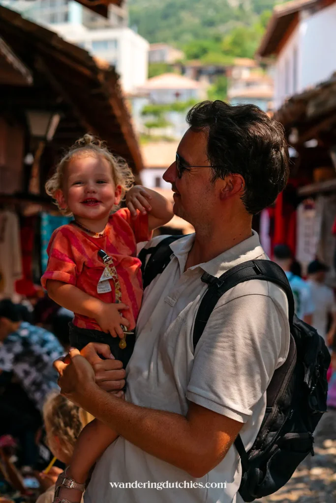 Vader en dochter genieten samen van de gezellige sfeer in de oude bazaar van Krujë, Albanië.