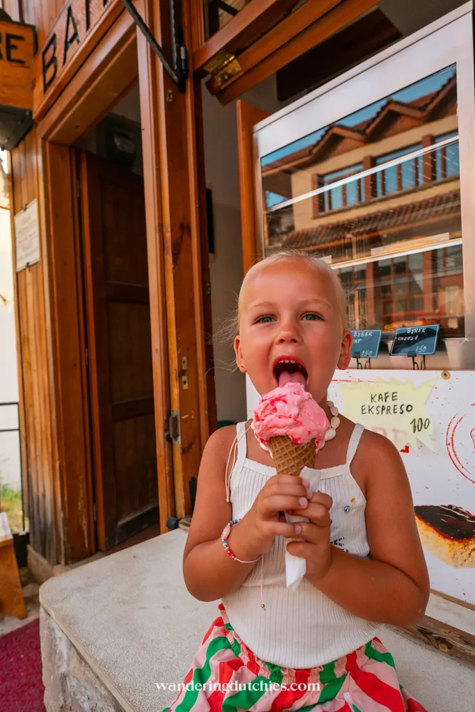 Kind eet een ijsje voor een lokale ijssalon in Krujë, Albanië.