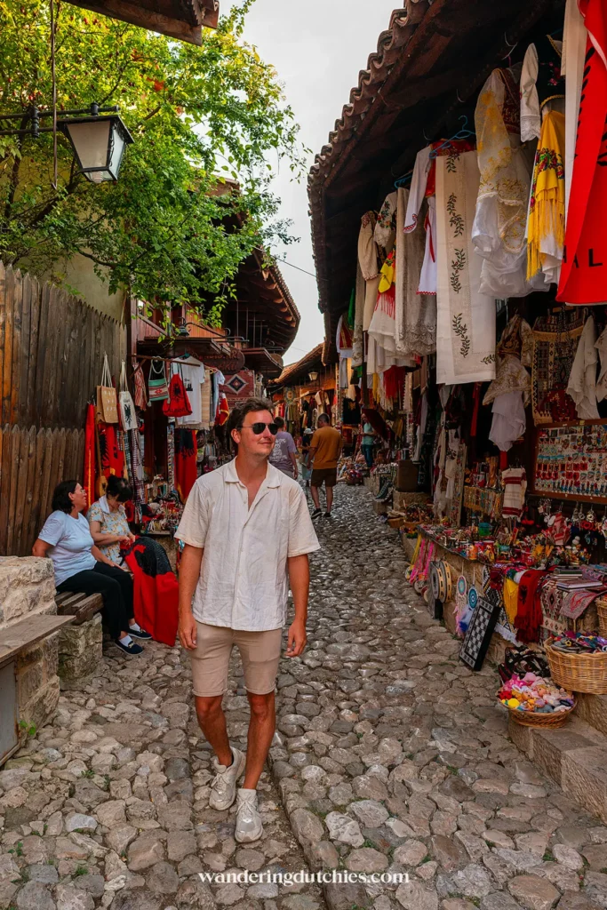 Wandelen door de bazaar van Krujë vol kleurrijke kleding.