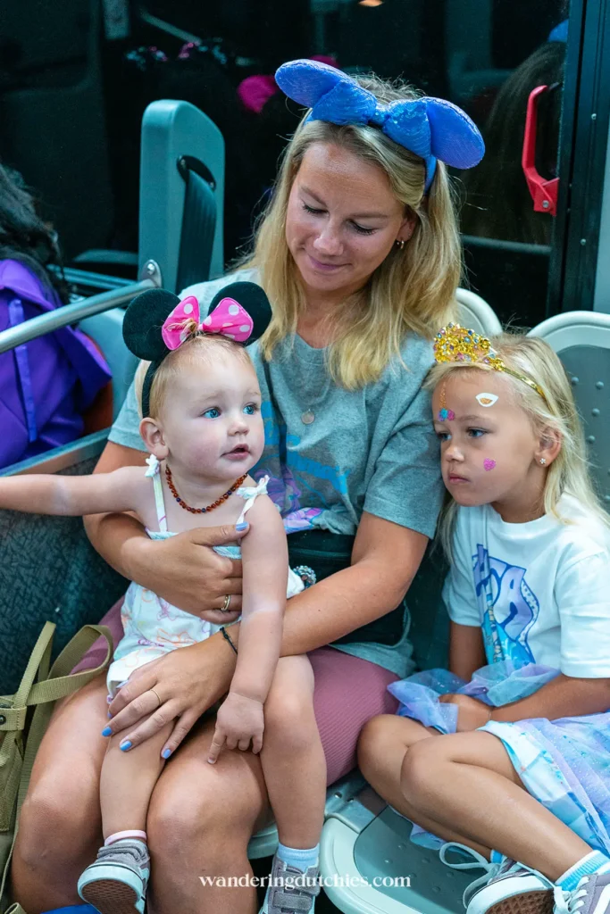 Moeder met jonge kinderen vroeg op pad in de Disney-bus voor maximaal early-entry genot in Walt Disney World.