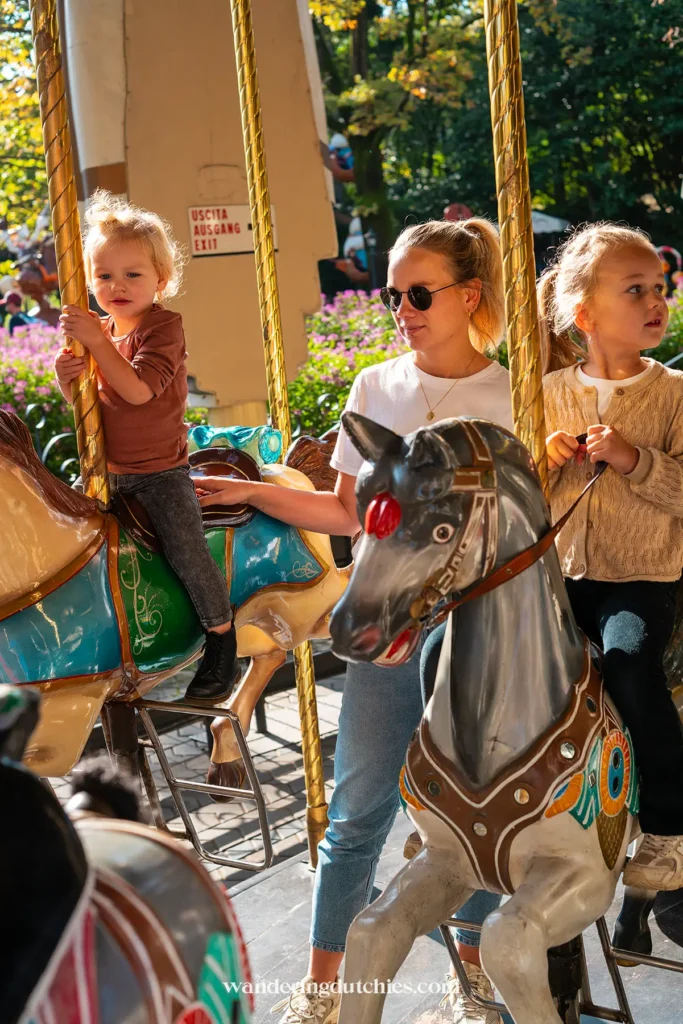 Moeder met kinderen op een draaimolen in Gardaland