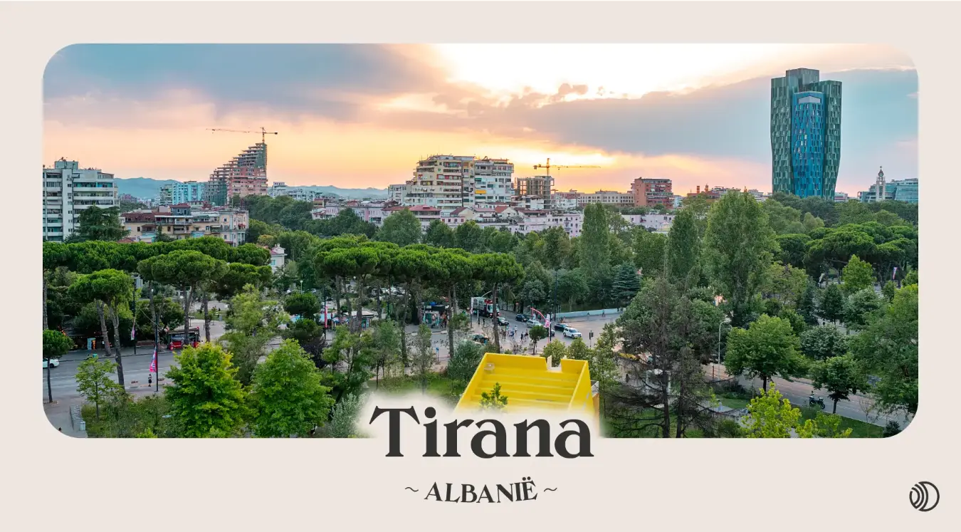 Uitzicht op Tirana bij zonsondergang met moderne en kleurrijke gebouwen en veel groen in het stadscentrum, Albanië