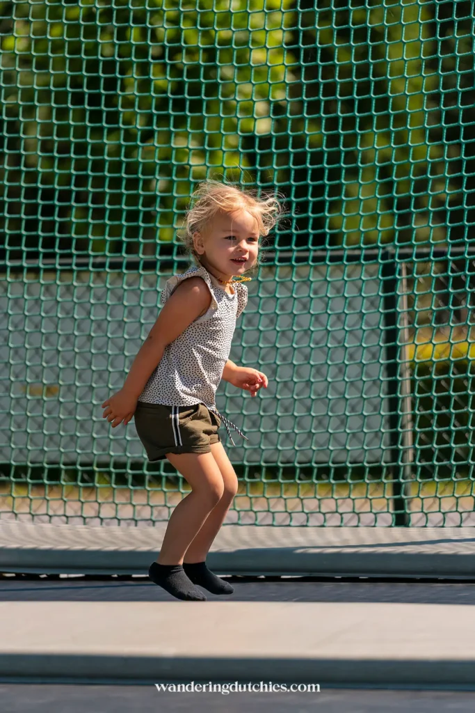 Jong meisje springt op een trampoline in de buitenlucht bij de Gitstappermolen