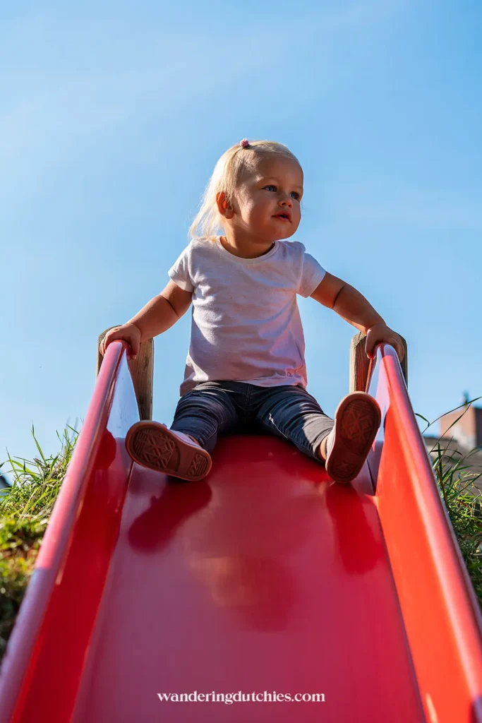 Meisje op een glijbaan in speeltuin de Speelkoel in St Joost