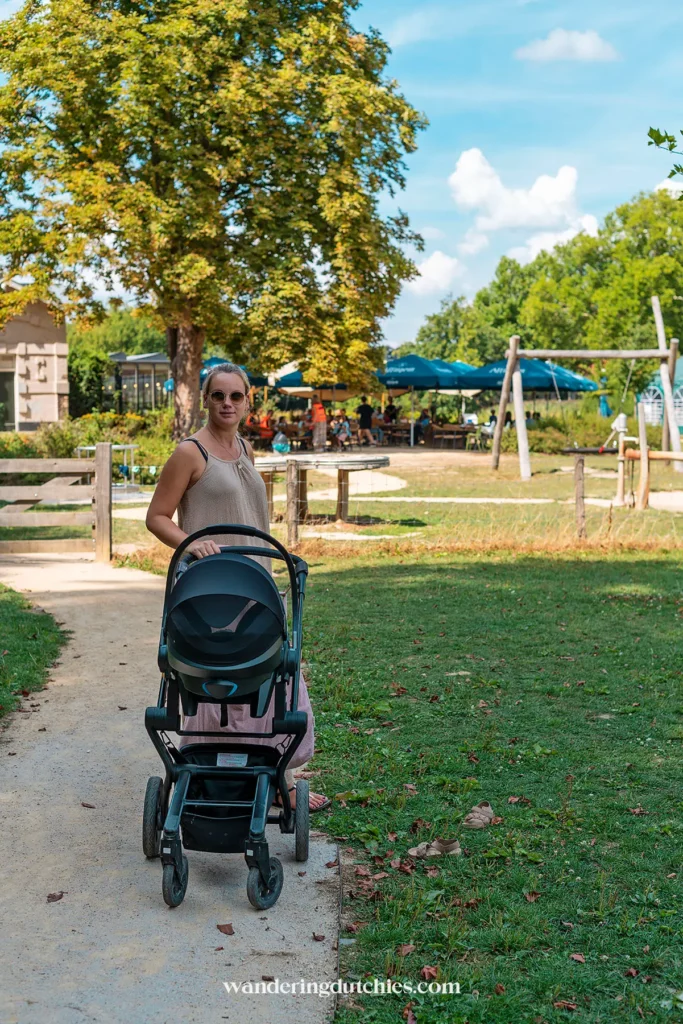 Moeder met kinderwagen bij Kanjel in Maastricht met speeltuin op de achtergrond