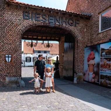 Gezin bij de ingang van restaurant Biesenhof in Geleen, onder sfeervolle poort met lichtletters in zomerse setting