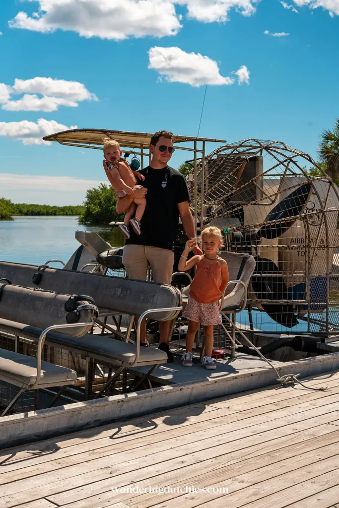 Vader met kinderen staat bij een airboat in de Everglades, Florida