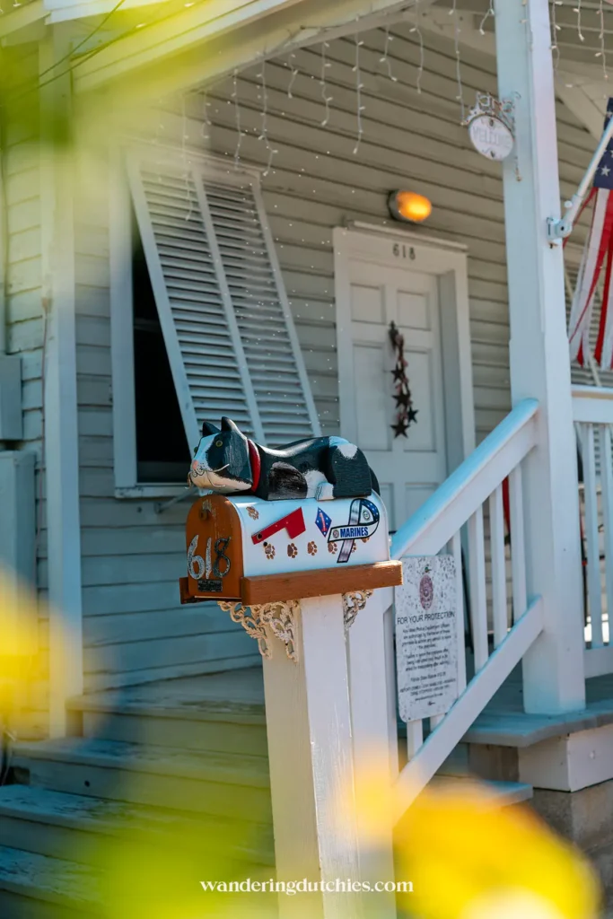 Decoratieve brievenbus met liggende kat voor een houten veranda in Key West, Florida Keys