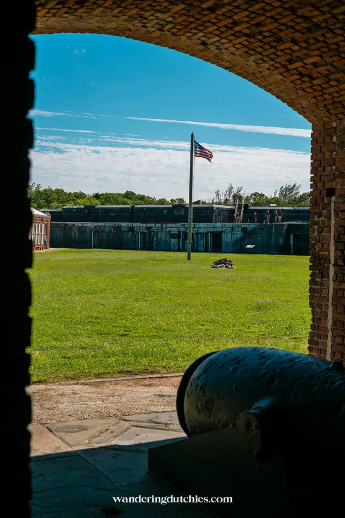 Binnenplaats van Fort Zachary Taylor in Key West gezien door een bakstenen boog, kanon op de voorgrond en Amerikaanse vlag.