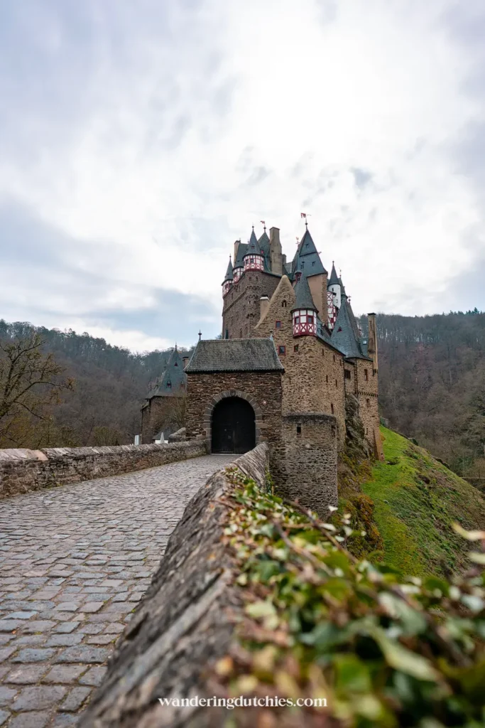 Bridge leading to the entrance of Burg Eltz in Germany, with the castle in the background.