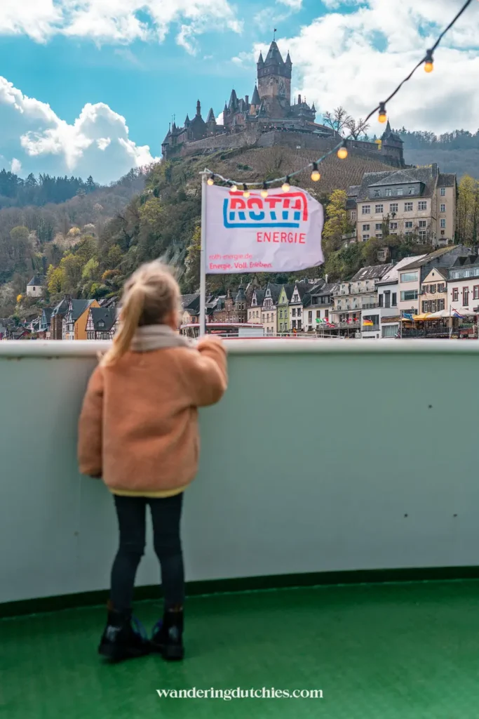 Child on a boat looking out over the Moselle at Reichsburg Cochem, Germany.