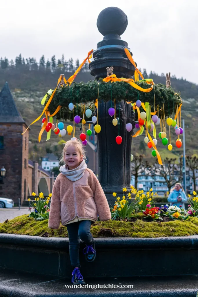 Child at a colorfully decorated Easter fountain in Cochem on the Moselle.