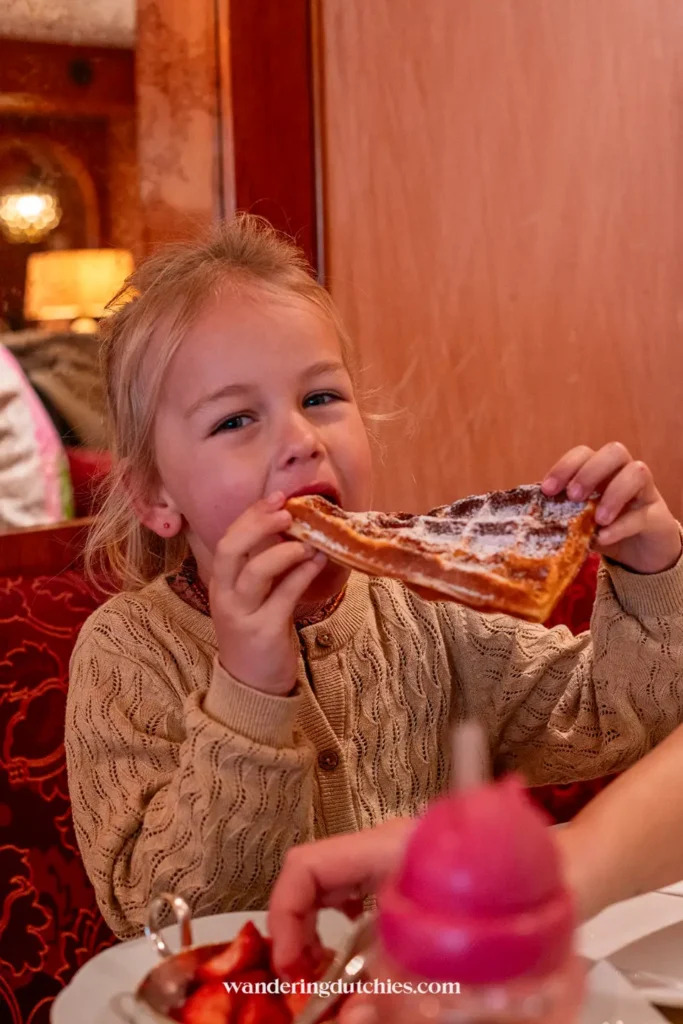 Child enjoying a German waffle in a café in Cochem.