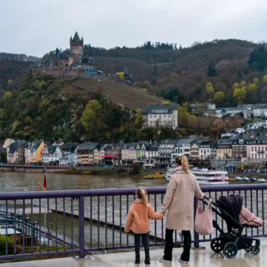 Moeder met kinderen kijkt uit op Reichsburg Cochem boven de Moezel.