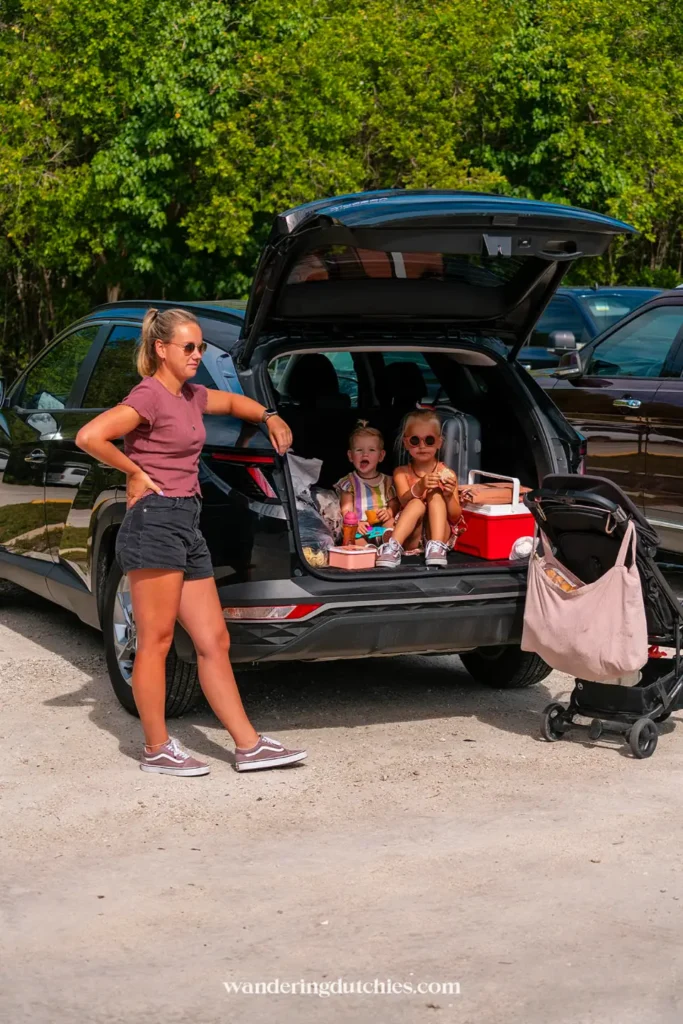 Gezin met kinderen pauzeert bij huurauto tijdens roadtrip door Florida