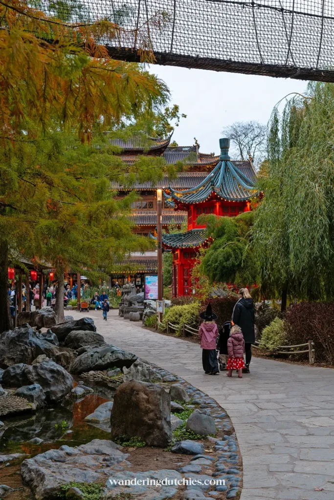 Familie wandelt door de Chinese tuin van Pairi Daiza met kinderen tijdens Halloween.