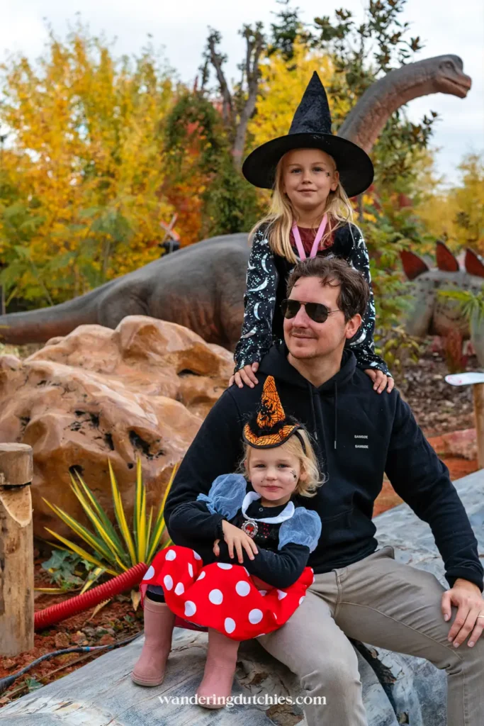 Vader met twee kinderen verkleed tijdens Halloween in het Dinosaurs-gebiedvan Pairi Daiza, een leuk uitje in België met kinderen