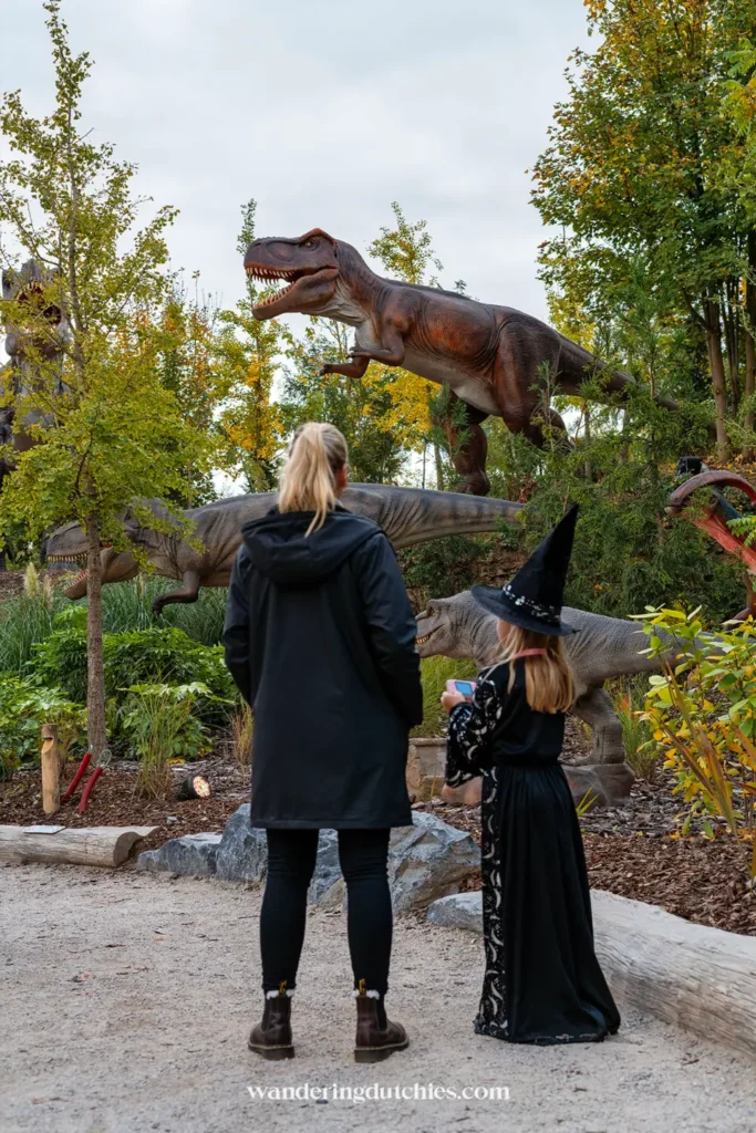 Moeder en dochter bekijken de levensgrote dinosaurussen in Pairi Daiza, perfect voor een daguitje met kinderen.