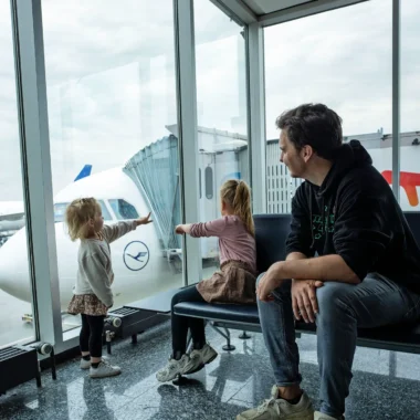 Gezin met kinderen kijkt naar vliegtuigen op Frankfurt Airport.