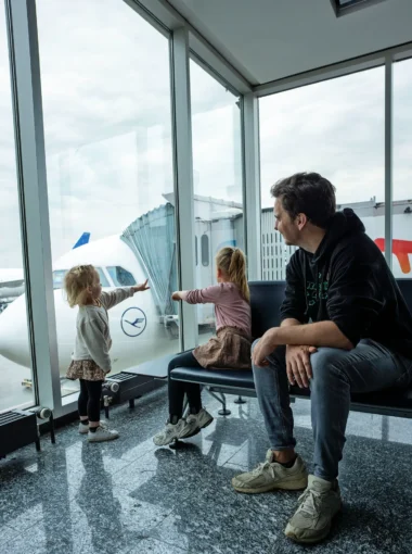 Gezin met kinderen kijkt naar vliegtuigen op Frankfurt Airport.