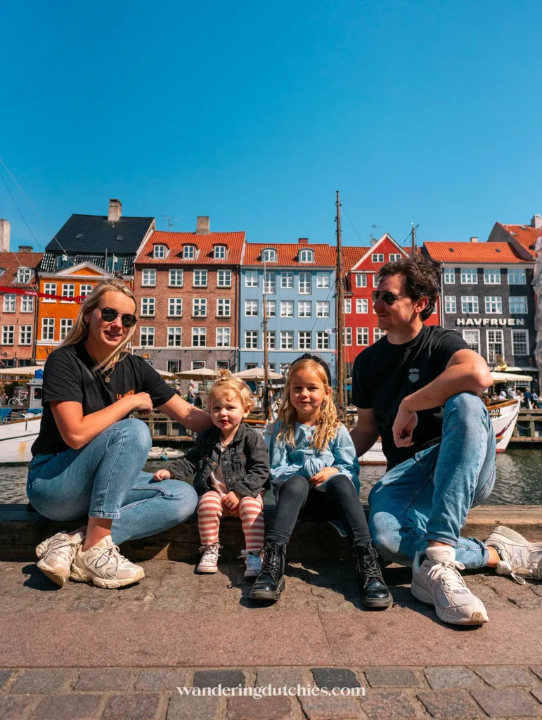 Gezinsfoto aan de kade van Nyhavn met kleurrijke huizen op de achtergrond