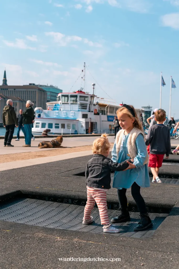 Onze kinderen spelend op de trampolines bij de haven van Kopenhagen