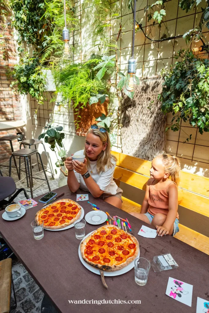 Moeder en dochter lunchen met pizza bij Kafé Magasinet in Göteborg, een kindvriendelijk restaurant met binnentuin.